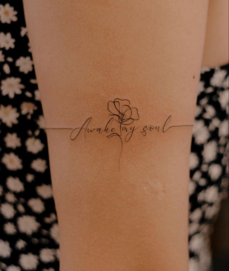 the back of a woman's stomach with a small tattoo on her left side