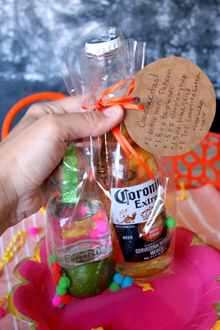 a person holding up a bottle with candy in it and a note attached to it