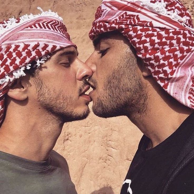 two men with heads coverings kissing each other