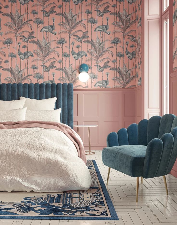 a bedroom with pink walls, blue chairs and a large bed in the middle of it