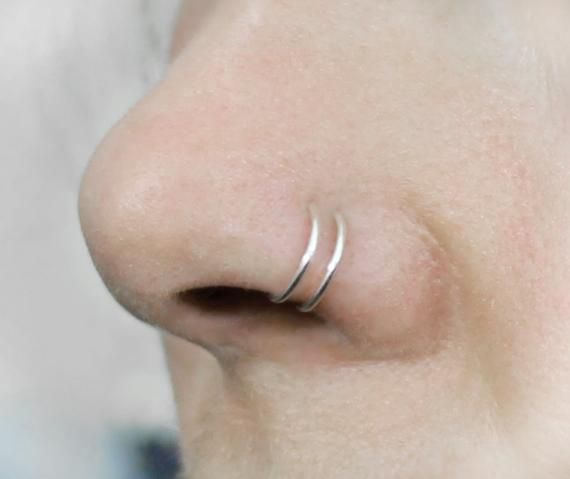 a close up view of a nose with two rings on it