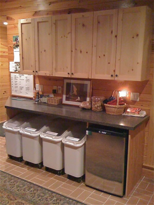 a kitchen with wooden cabinets and white trash cans