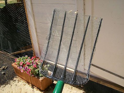 an outdoor chicken coop with flowers growing out of the ground and in front of it