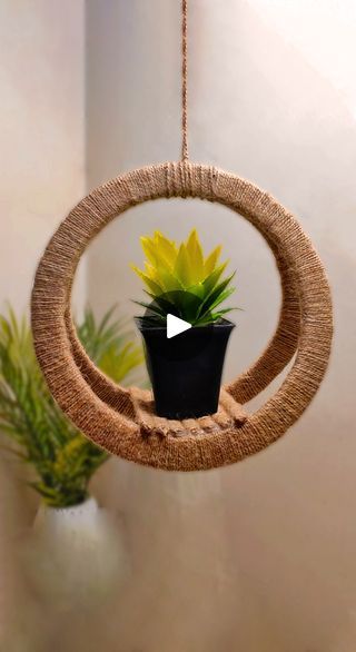 a hanging planter with a yellow flower in it