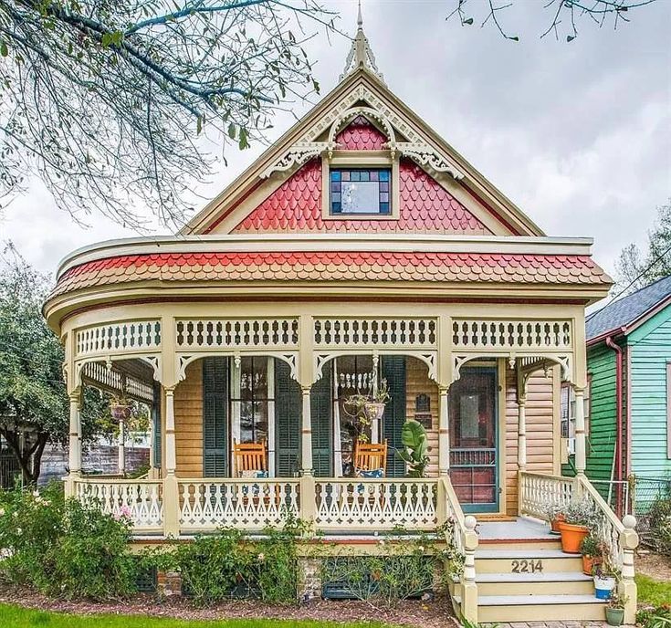 a small house with a red roof and white trim on it's front porch