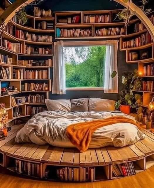 a circular bed in the middle of a room with bookshelves on both sides