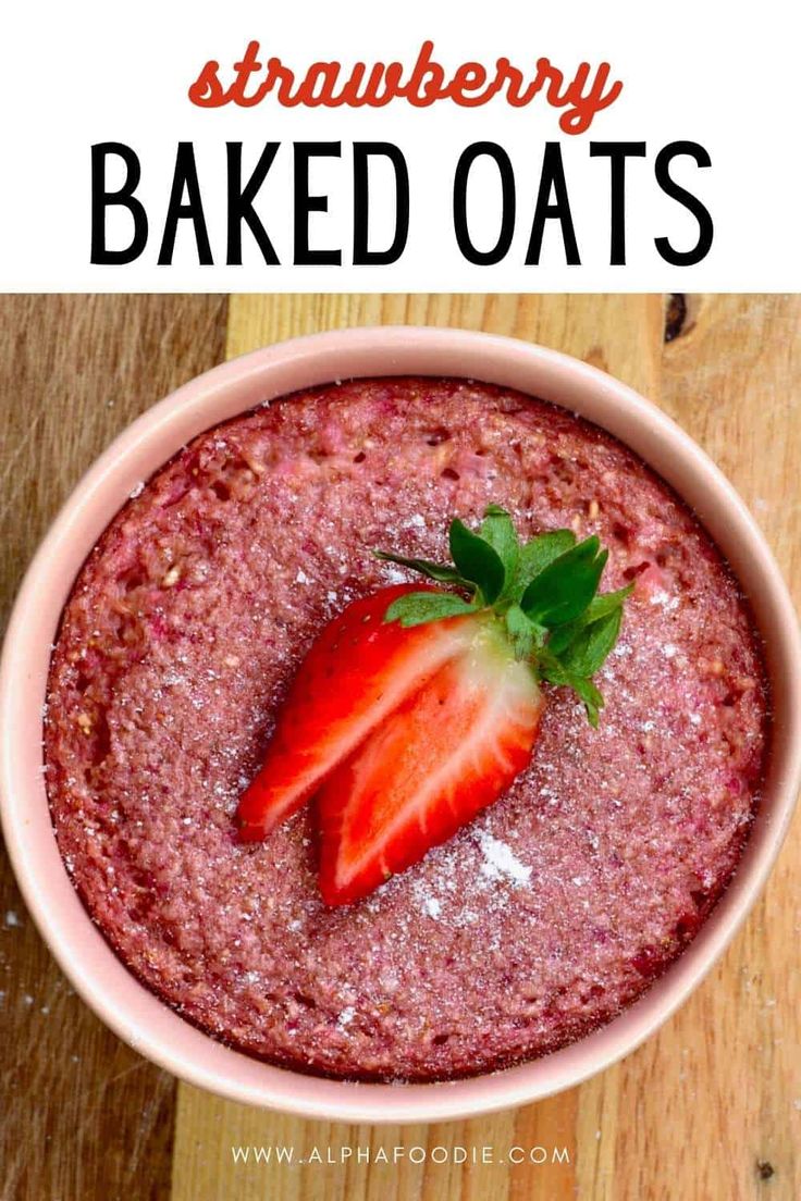 strawberry baked oats in a pink bowl on a wooden table with text overlay