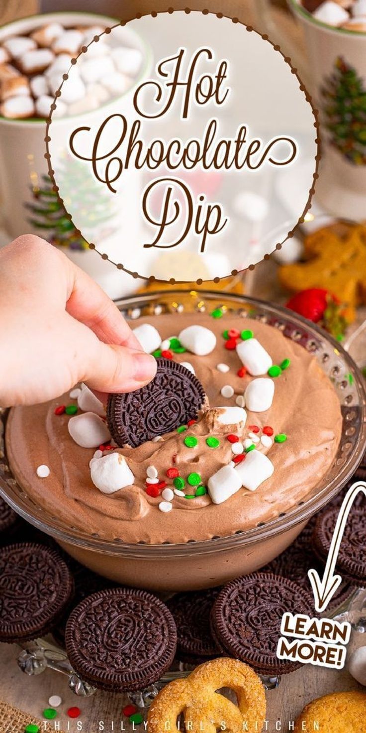 a person dipping a cookie into a bowl of hot chocolate dip with marshmallows and pretzels