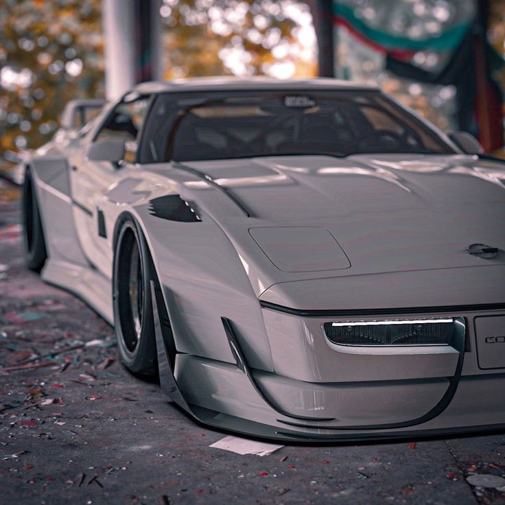 a silver sports car parked in front of a building