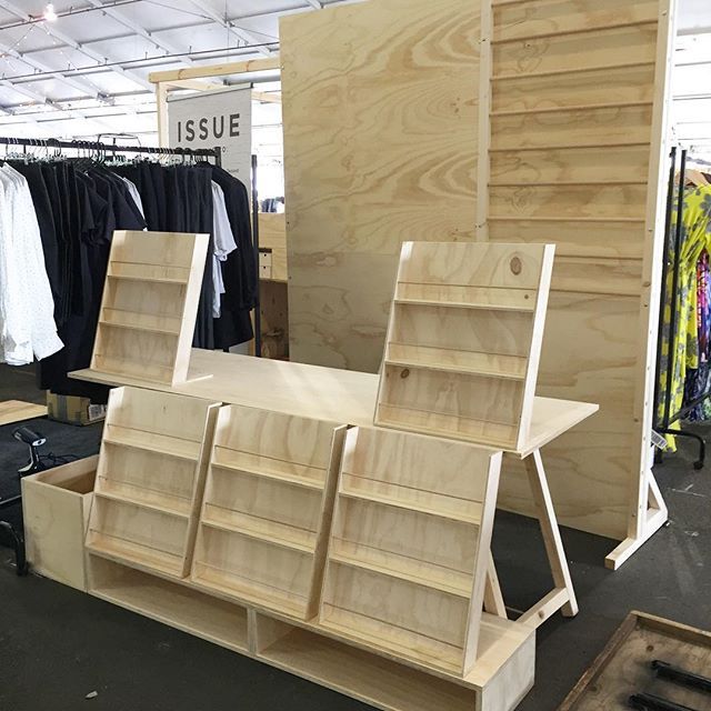 some wooden shelves and clothes racks in a store