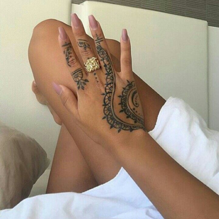 a woman laying in bed with her legs spread out and tattoos on her hands,