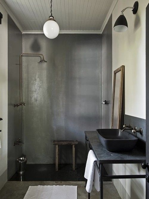 a bathroom with a sink, mirror and shower stall in the corner next to it