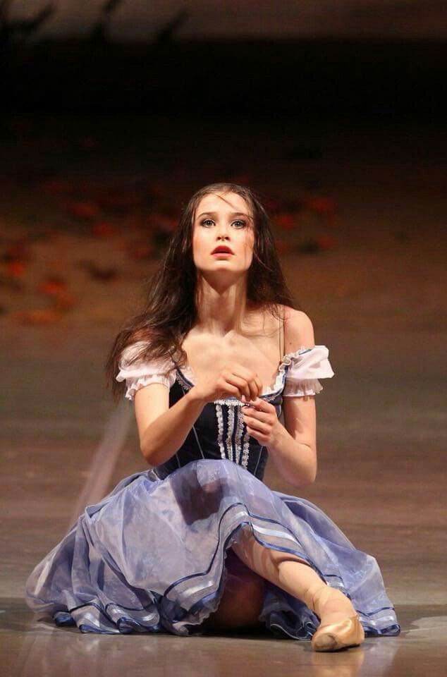 a woman in a blue dress sitting on the ground