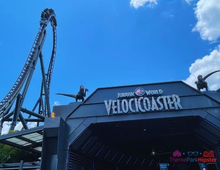 an amusement park with a roller coaster in the background and people on it's side