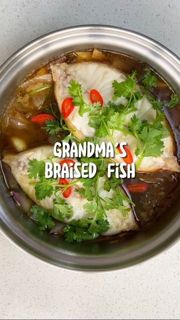 a bowl filled with fish and vegetables on top of a table