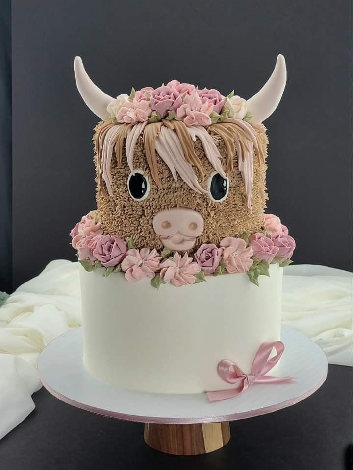 a cake decorated with flowers and a cow's head is on top of a table