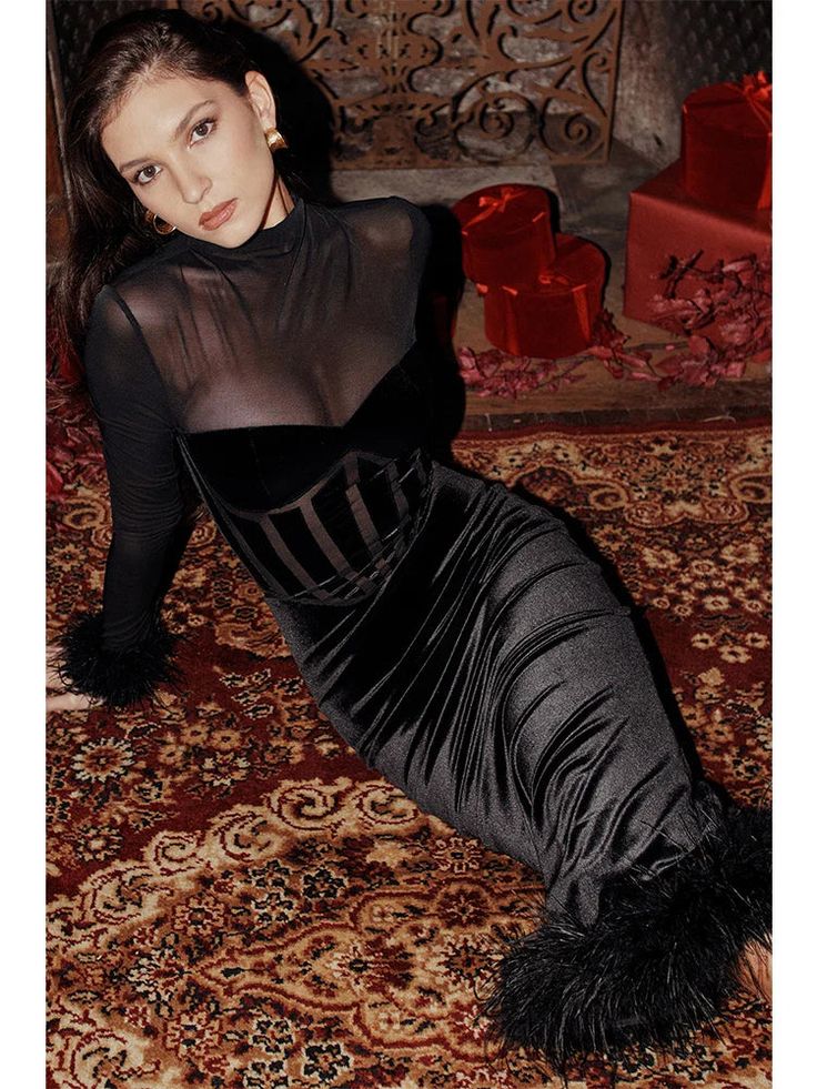 a woman laying on top of a rug wearing a black dress and fur stoler