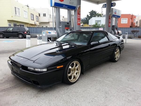 a black sports car parked at a gas station