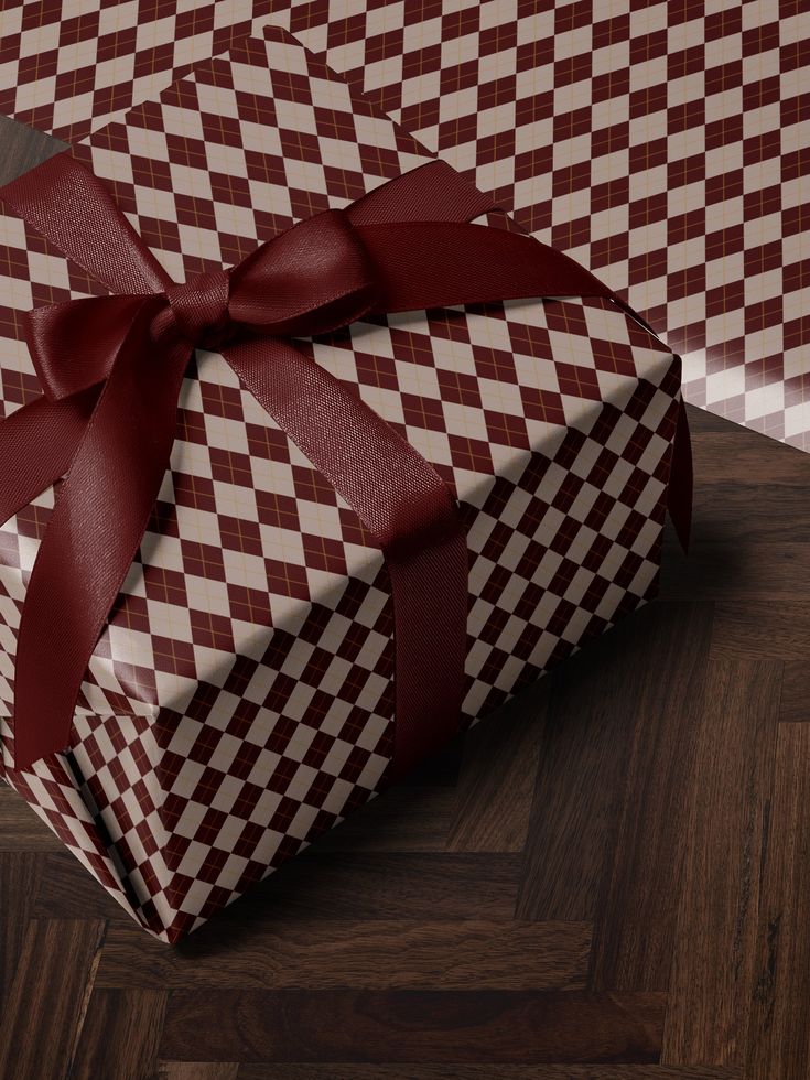 a large red and white checkered gift box with a bow on it's side