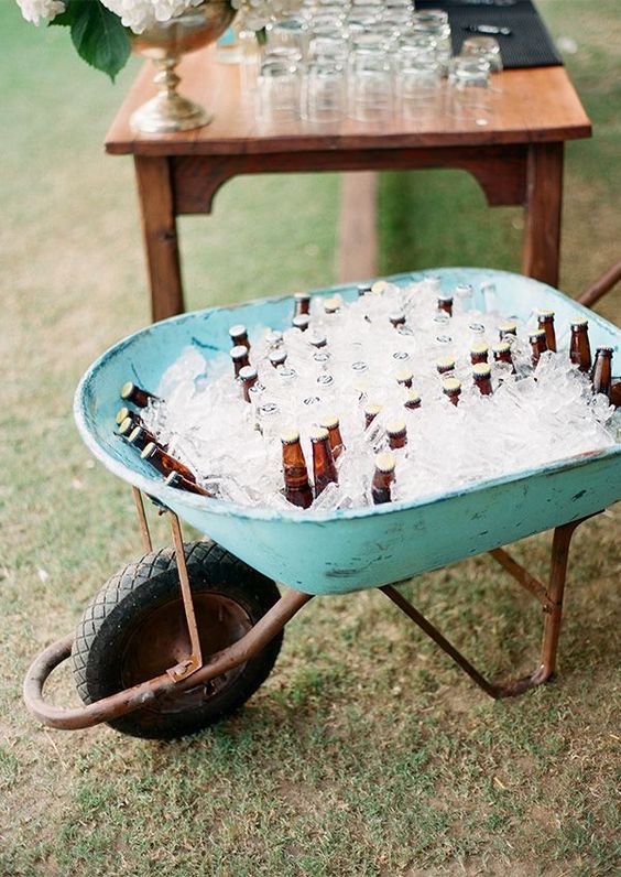 a wheelbarrow filled with beer bottles and ice