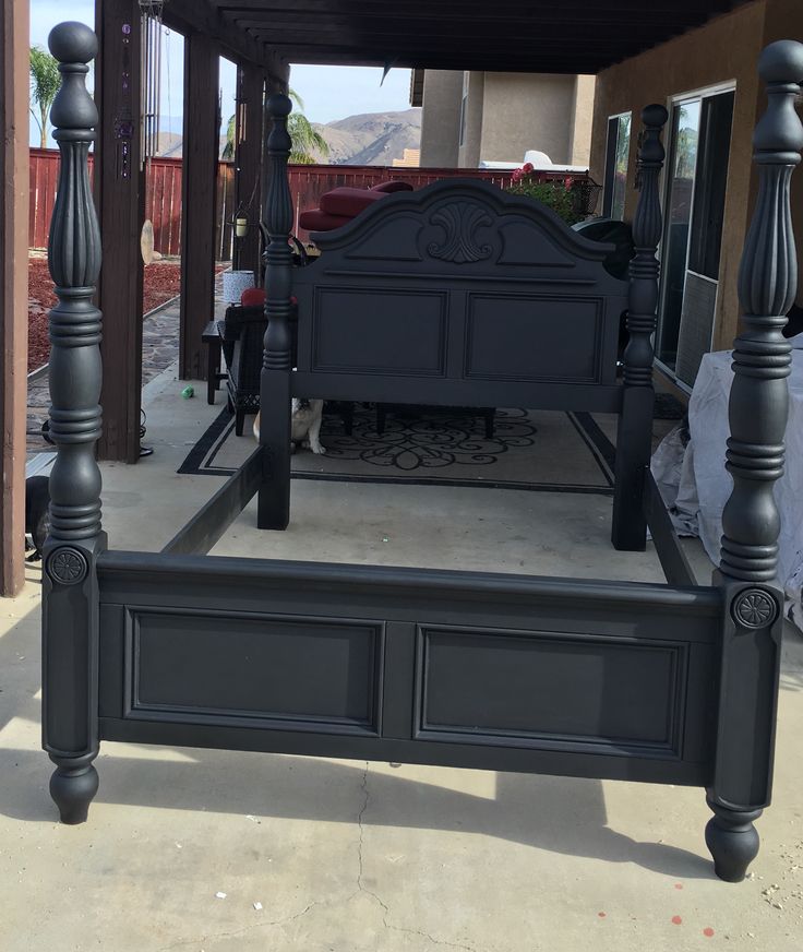 a black bed frame sitting on top of a sidewalk