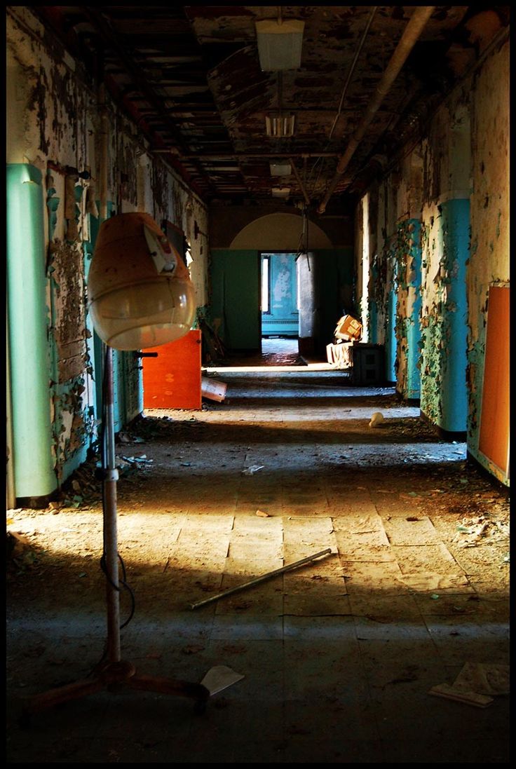 an old hallway with peeling paint and lots of trash on the ground in front of it