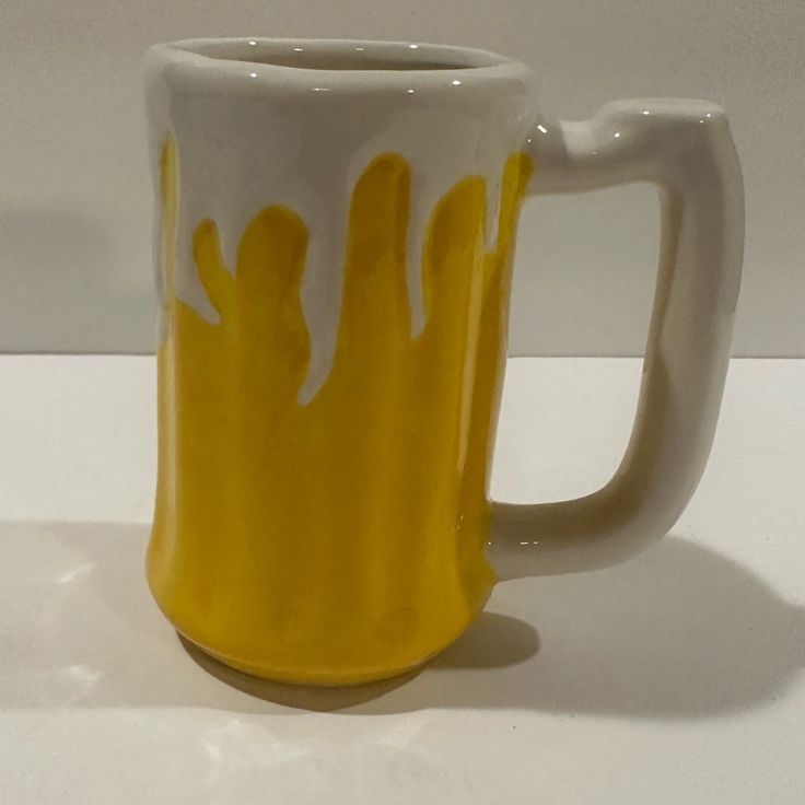 a yellow and white mug sitting on top of a table