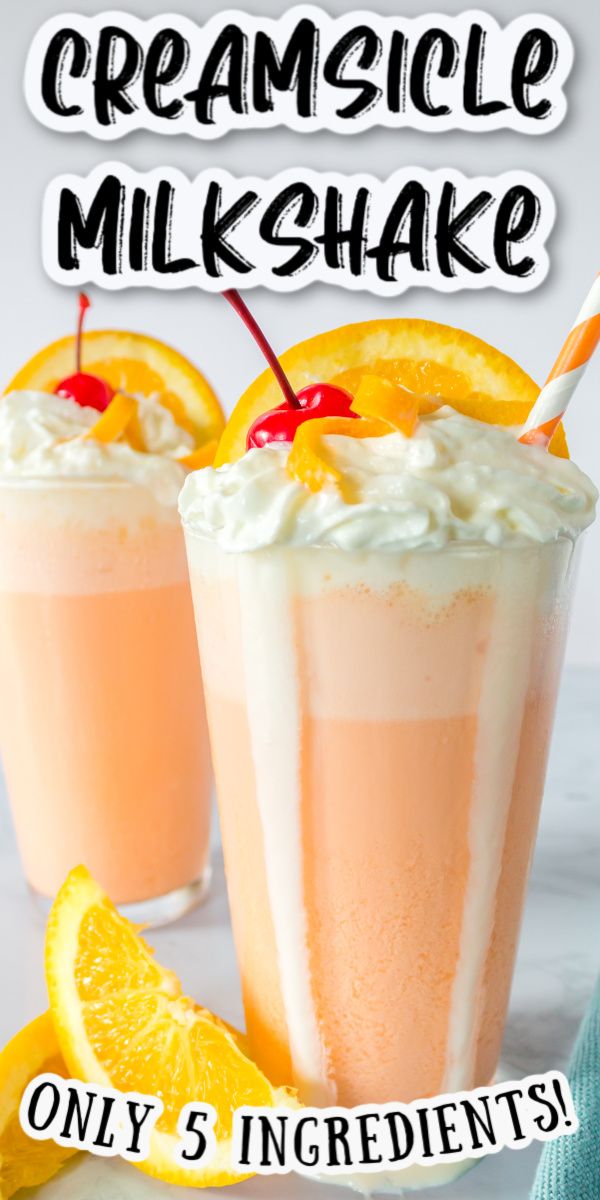 two orange creamsice milkshakes are garnished with cherries