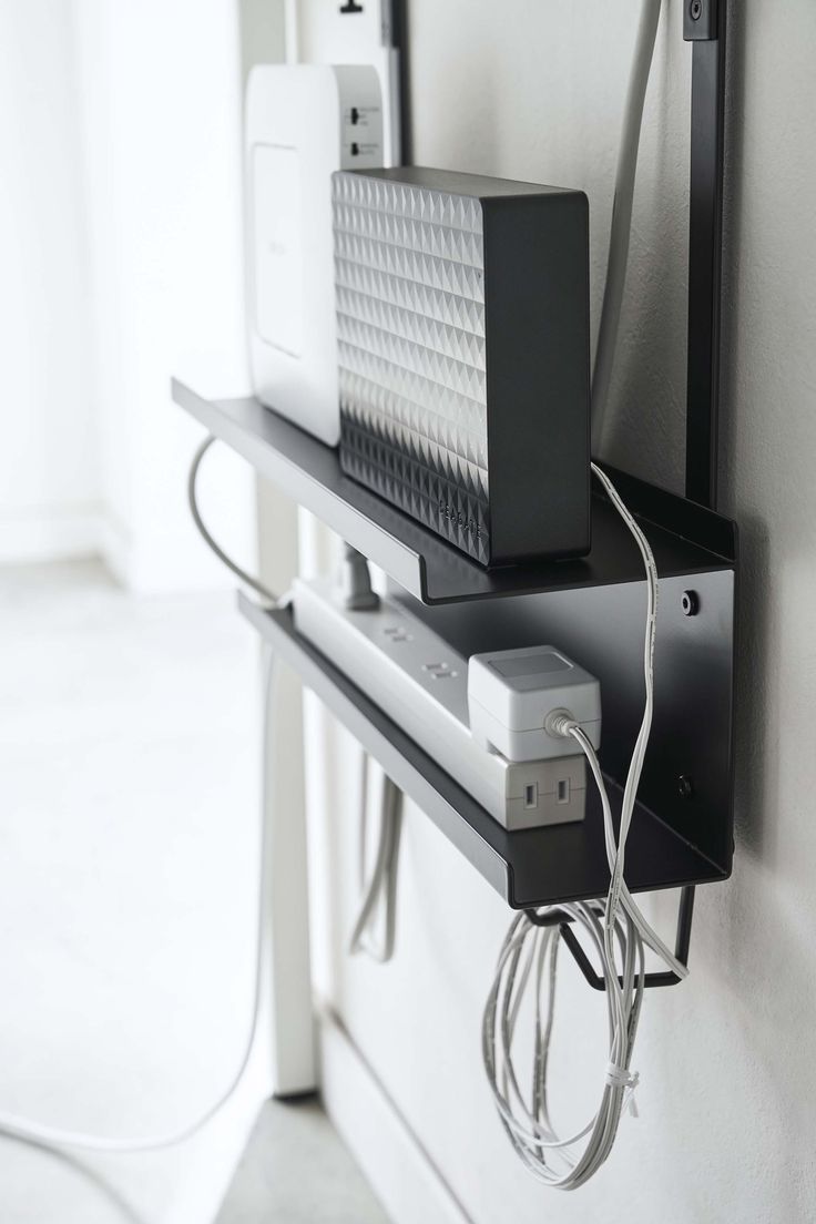 two electronic devices are plugged in to the wall with wires running from them and connected to each other