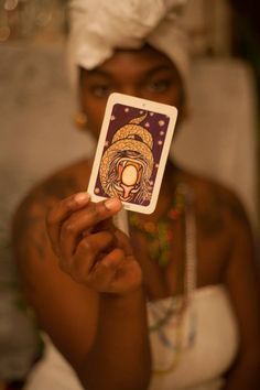 a woman holding up a card with an image on it in front of her face