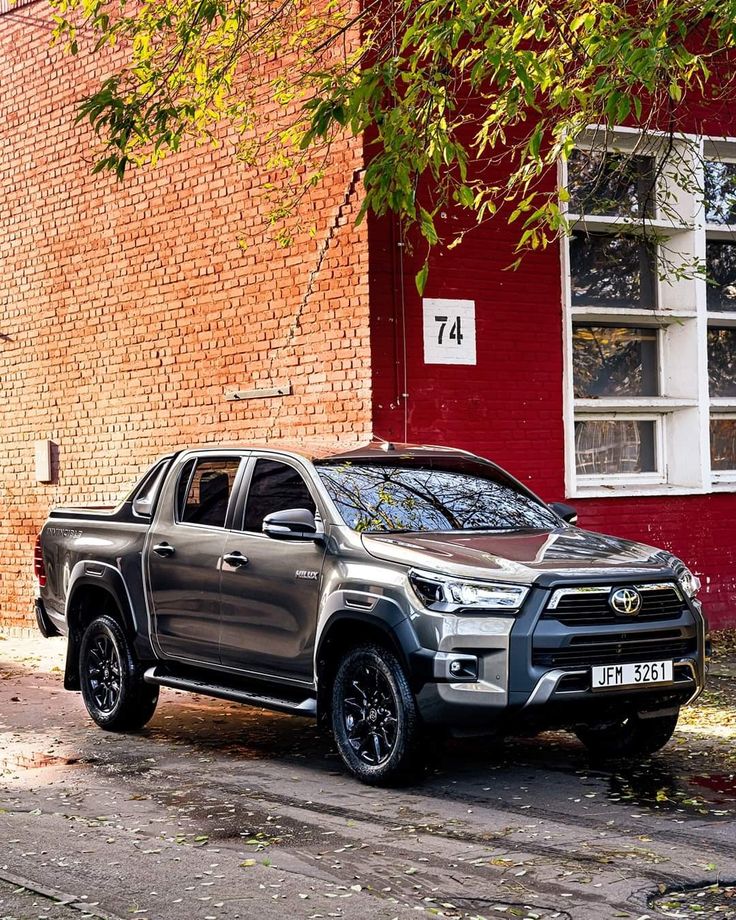 a silver truck parked in front of a red brick building