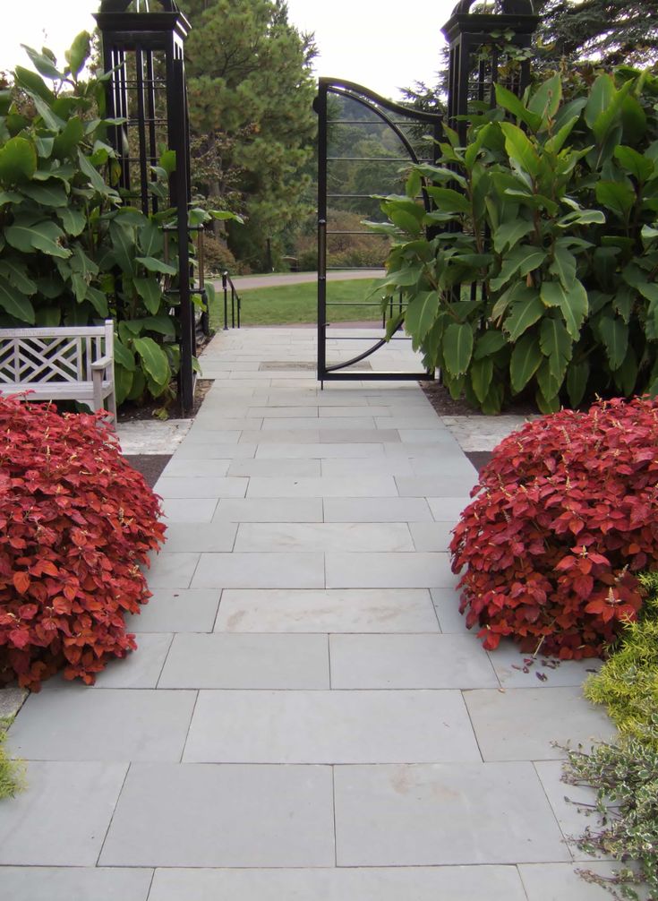 two white benches sitting in the middle of a garden