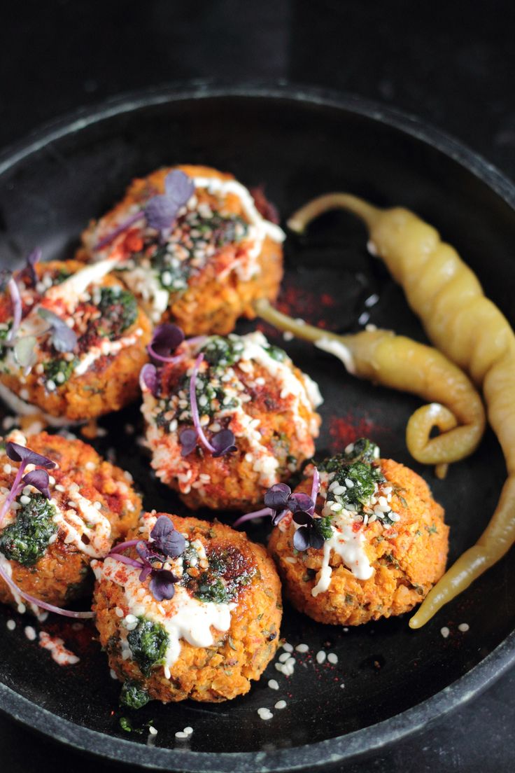 some food that is in a pan on a table next to a fork and pepper