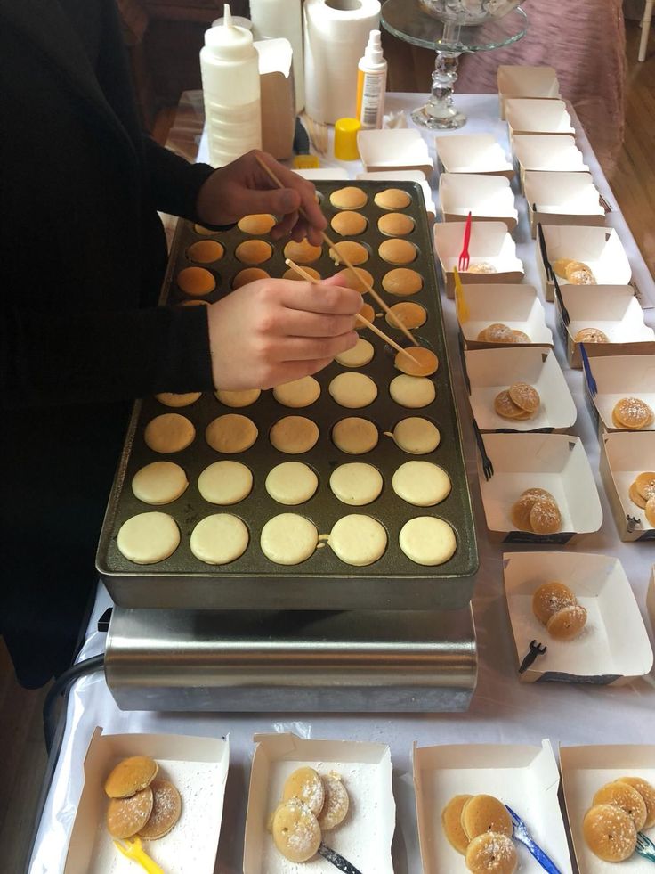 a table topped with lots of trays filled with donuts and muffins