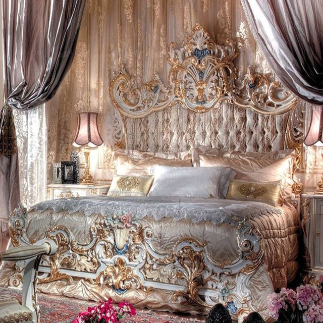 a fancy bedroom is decorated in gold and white colors, with pink flowers on the floor