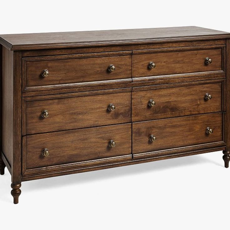 a wooden dresser with several drawers and knobs on the bottom drawer, against a white background