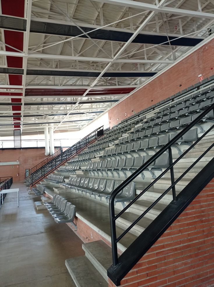 an empty stadium with rows of seats and railings on either side of the bleachers