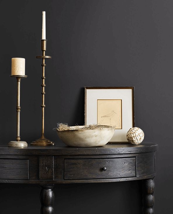 a wooden table with a bowl and candles on it next to a framed photograph in a frame