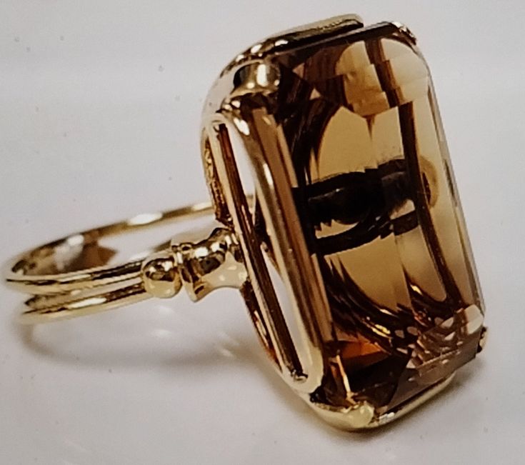 Vintage at its Best! This gorgeous Honey color Quartz stone is a whopping 20 Carats of pure beauty. Size 6 l/2 in pure Yellow 14K gold. From an estate sale, this ring is early 2000. You can tell by the setting of which this huge stone is nestled in a ribbon like design. They just don't make these beauties today. The large stone is an Emerald Cut and it is a very deep stone. You can see the depth of it in the under gallery of the ring. Beautifully faceted and mesmerizing when you look into the st Large Cocktail Rings, Large Gemstone Rings, Big Gold Rings, Stone Ring Design, Vintage Jewelry Rings, Large Stone Rings, Big Stone Ring, Honey Color, Color Quartz