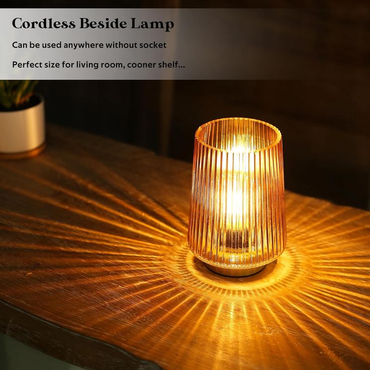 a light that is sitting on top of a wooden table next to a potted plant