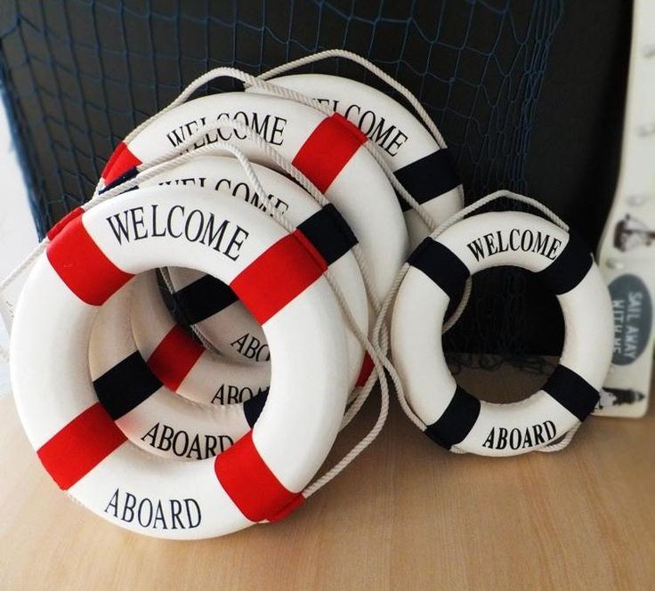 four life preservers sitting on top of a wooden table next to a black and white wall