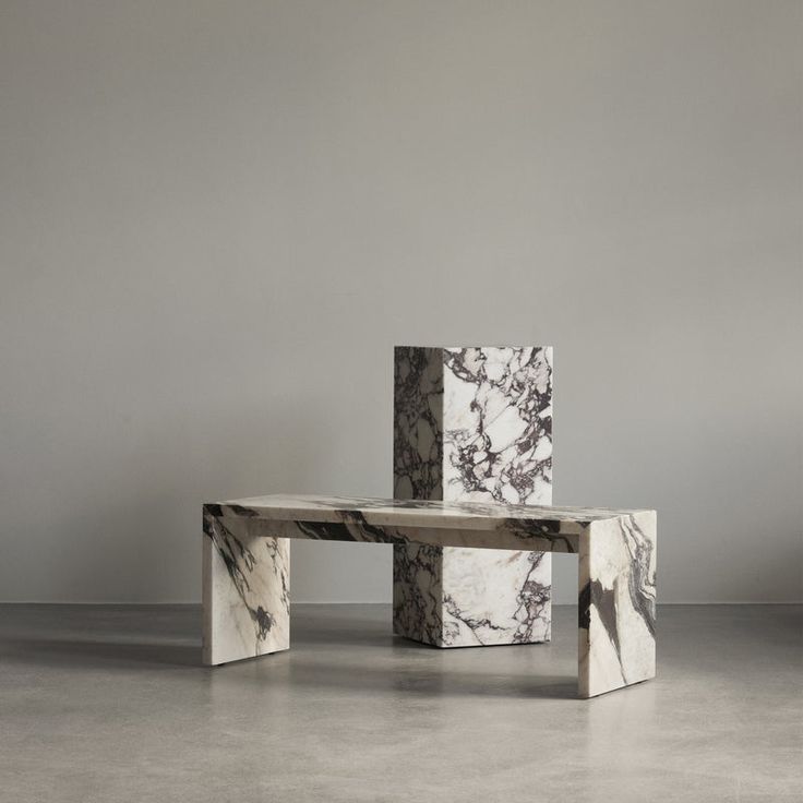 three marble tables stacked on top of each other in an empty room with grey walls