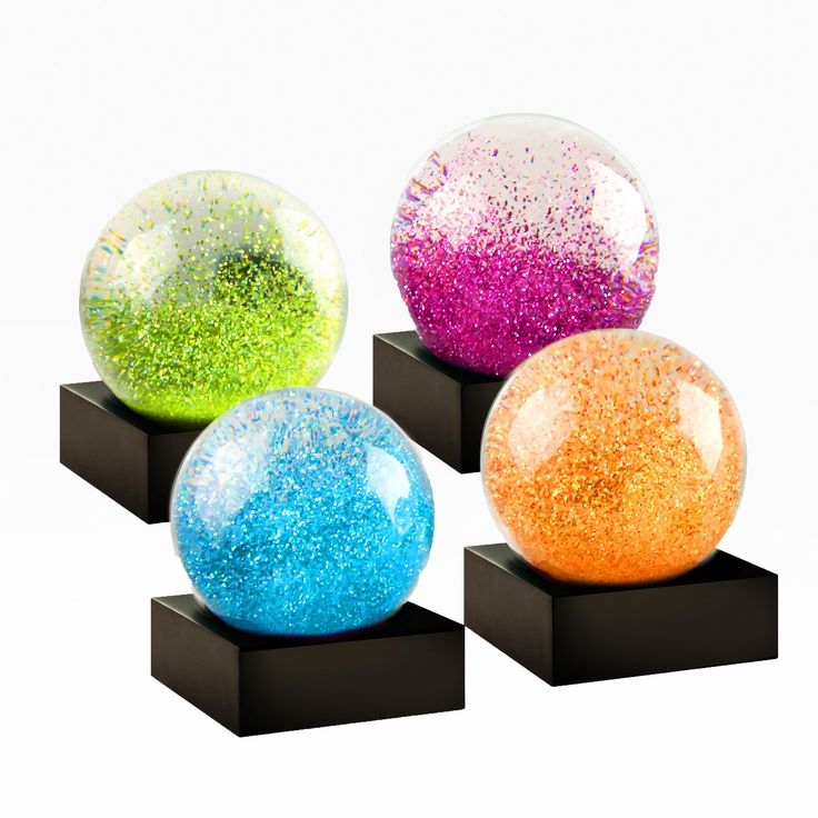 three different colored balls sitting on black stands