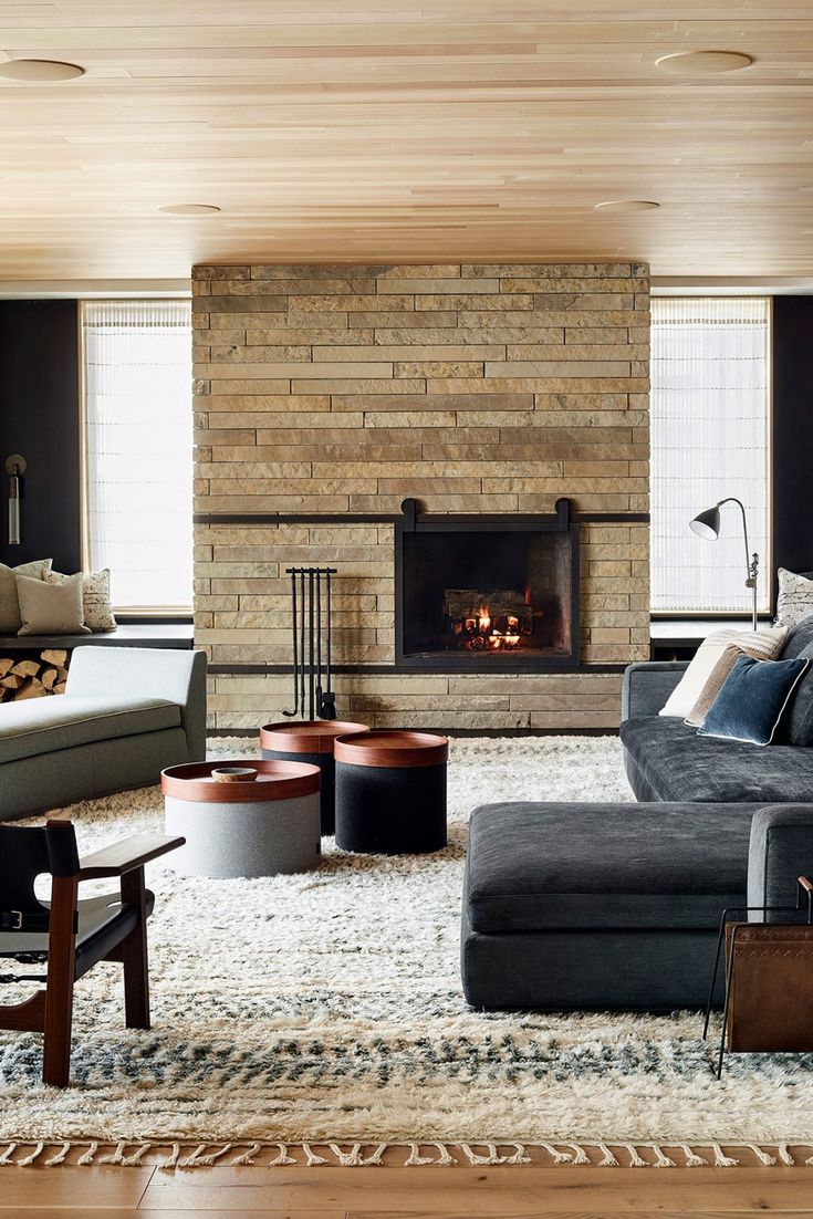 a living room filled with furniture and a fire place in the middle of the room