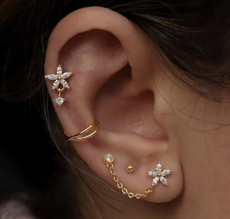 a woman's ear with three piercings on it