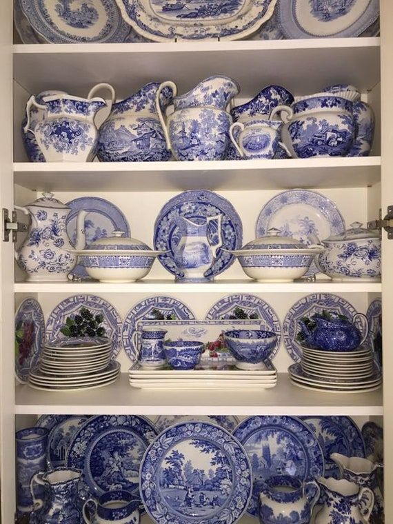 blue and white china is displayed on shelves