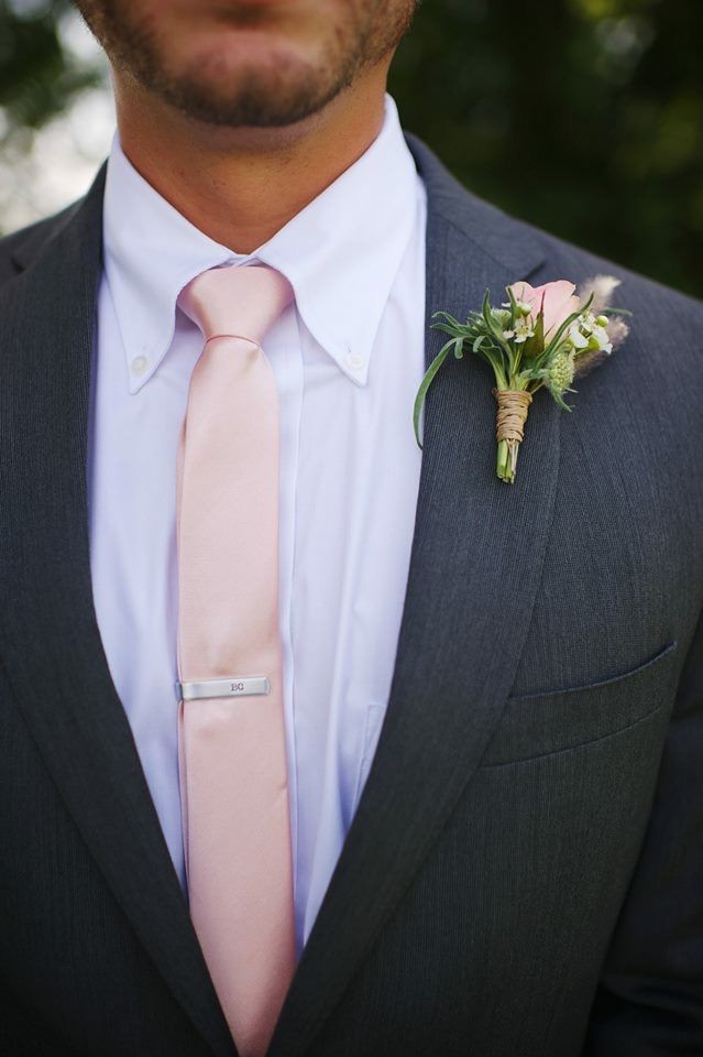 a man in a suit with a pink tie and boutonniere