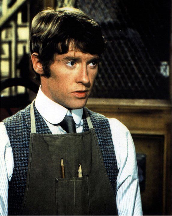 the young man is wearing an apron and tie