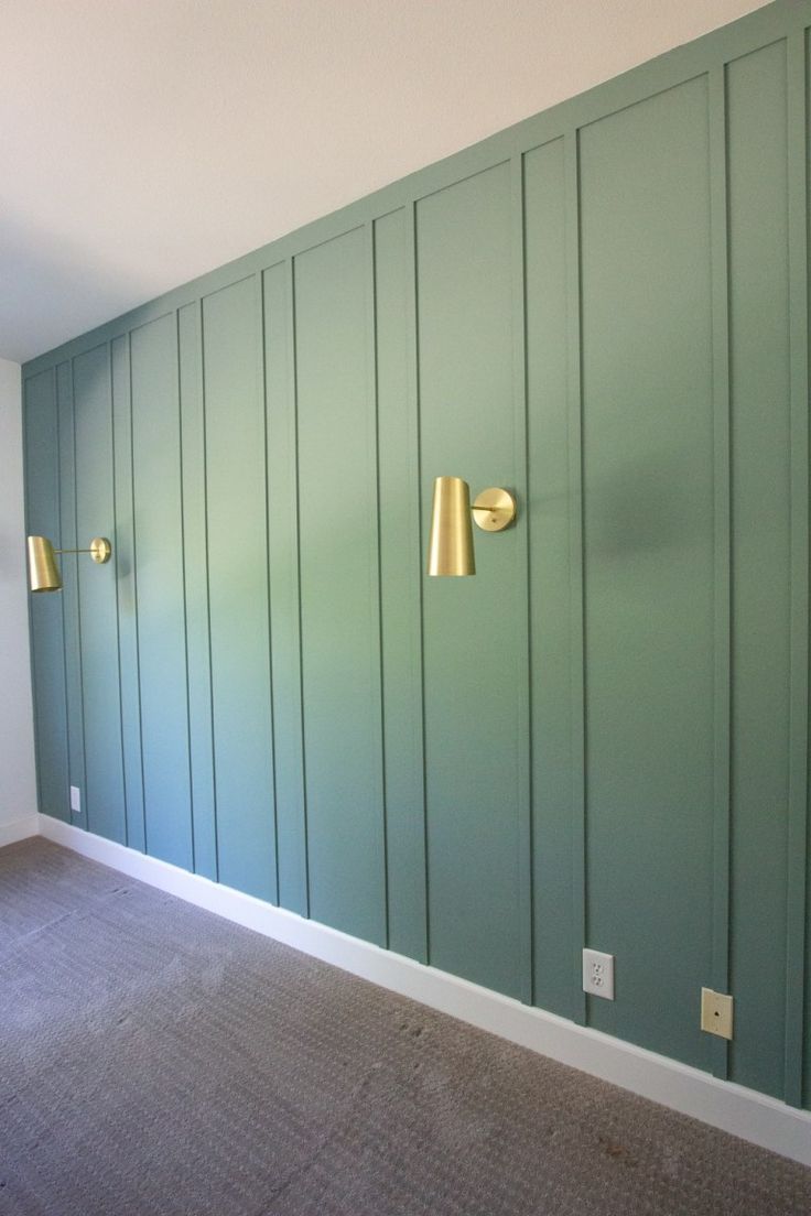 an empty room with green painted walls and gold knobs on the doors, carpeted floor