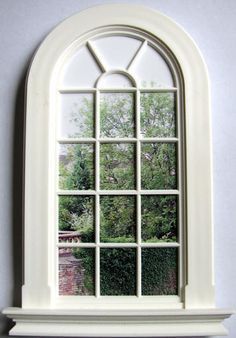 a white window with an arched glass on the wall